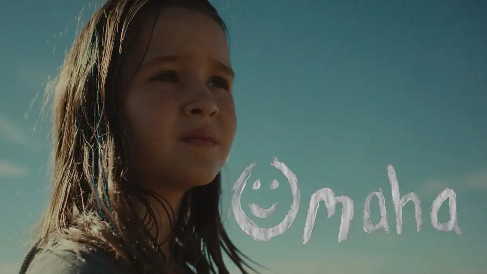 Young girl with wet hair looking at the ocean in Omaha.