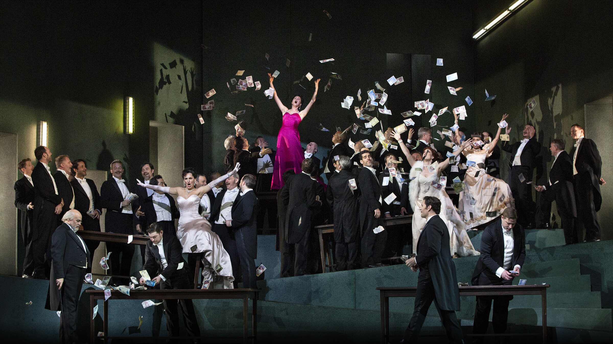 The company of Manon on stage at the Metropolitan Opera, banknotes flying through the air
